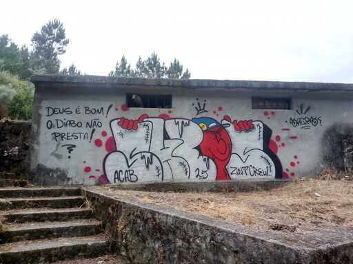 Graffitti of letters and a little red guy with a baseball cap spelling "SHEPS", "ZINT CREW", "DEUS É BOM! O DIABO NÃO PRESTA!" and "ACAB"