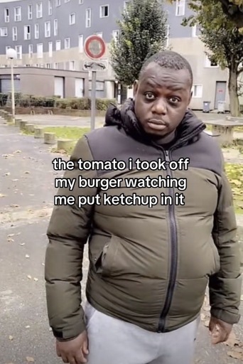 Photo of a man standing outside with a funny look on his face with the caption “the tomato i took off my burger watching me put ketchup in it”